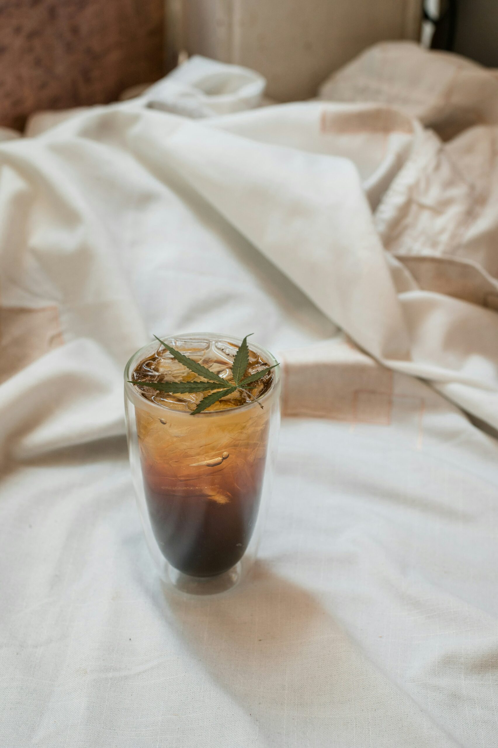 A glass of mushroom coffee on a bed